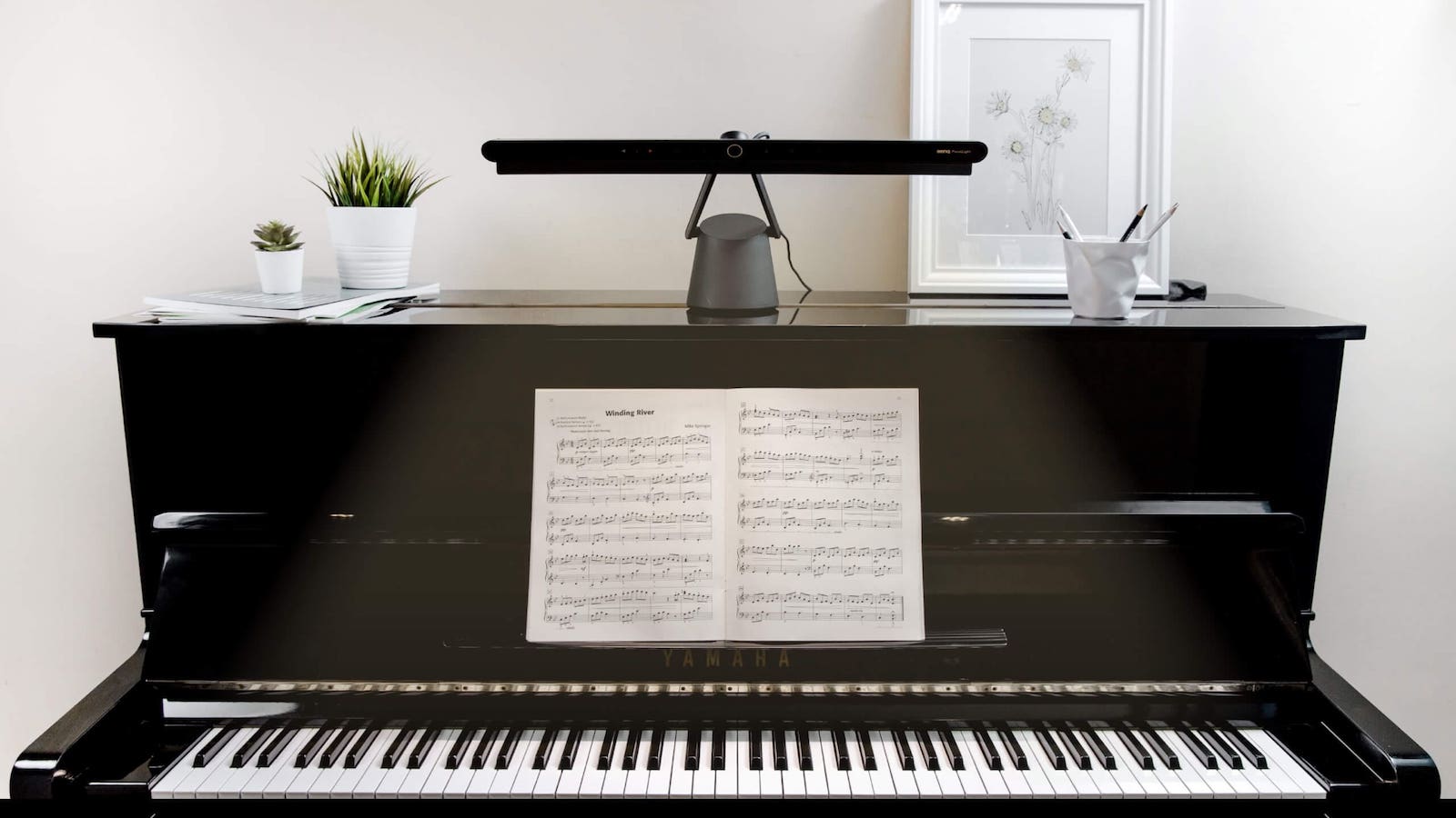 BenQ PianoLight eye care lamp illuminates sheet music and piano